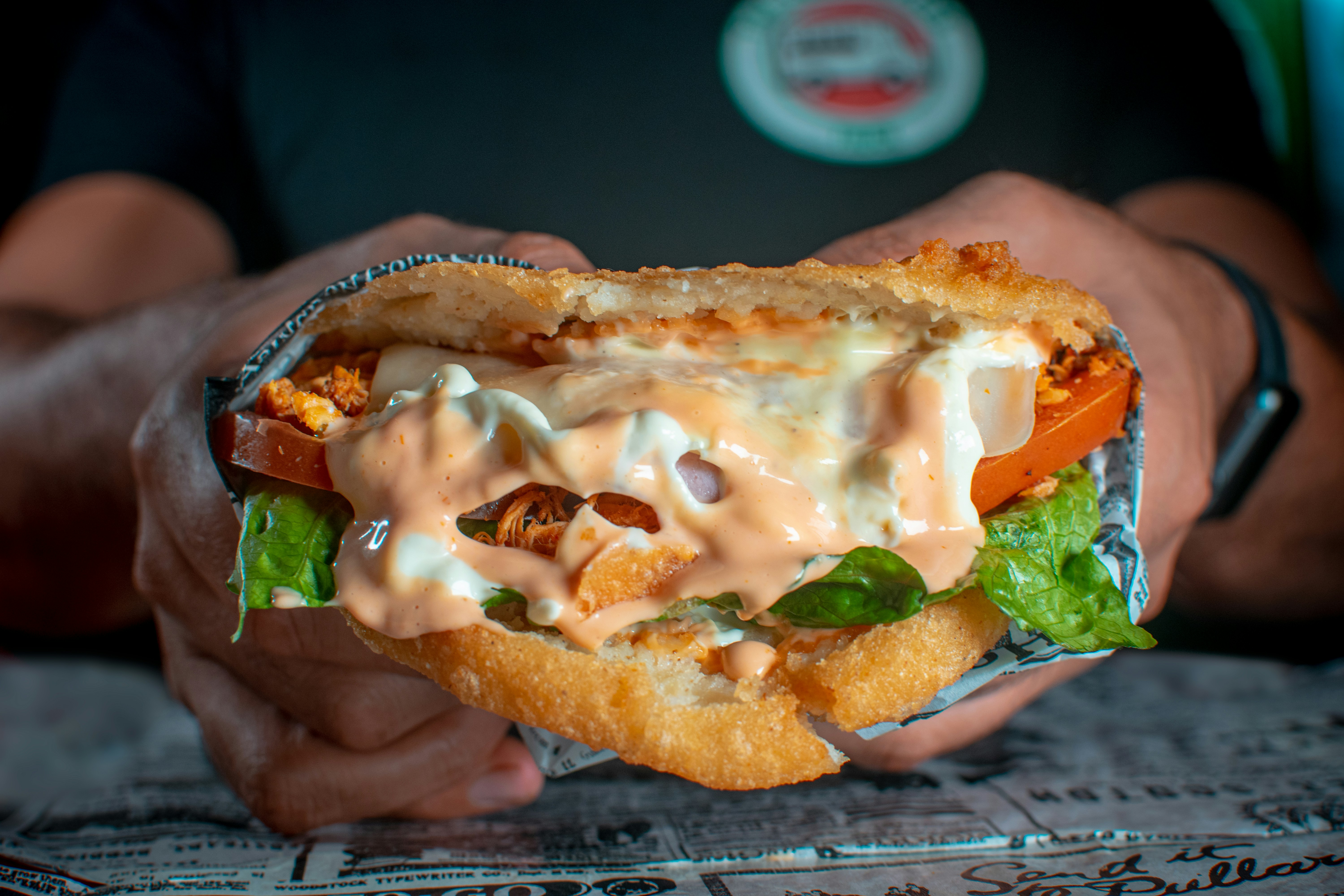 Person holding a loaded sandwich
