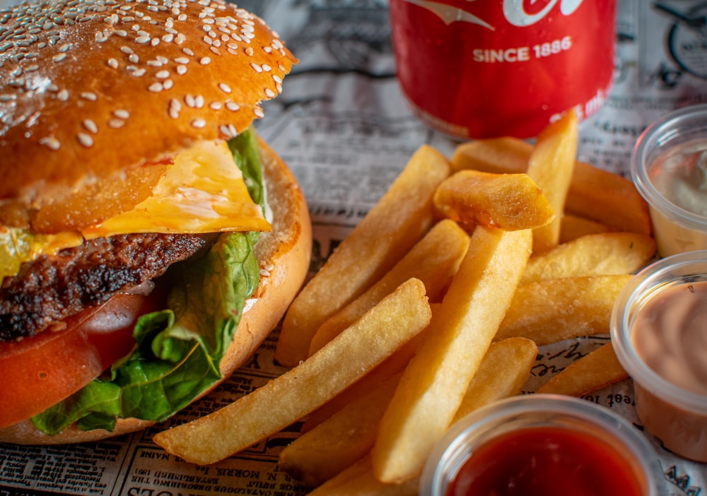 a hamburger and french fries with ketchup and a drink