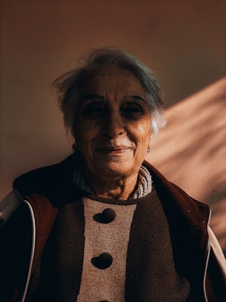 A candid shot of a transgender elder sharing a quiet moment in a cozy indoor setting.