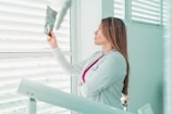 a woman in a white lab coat looking out a window
