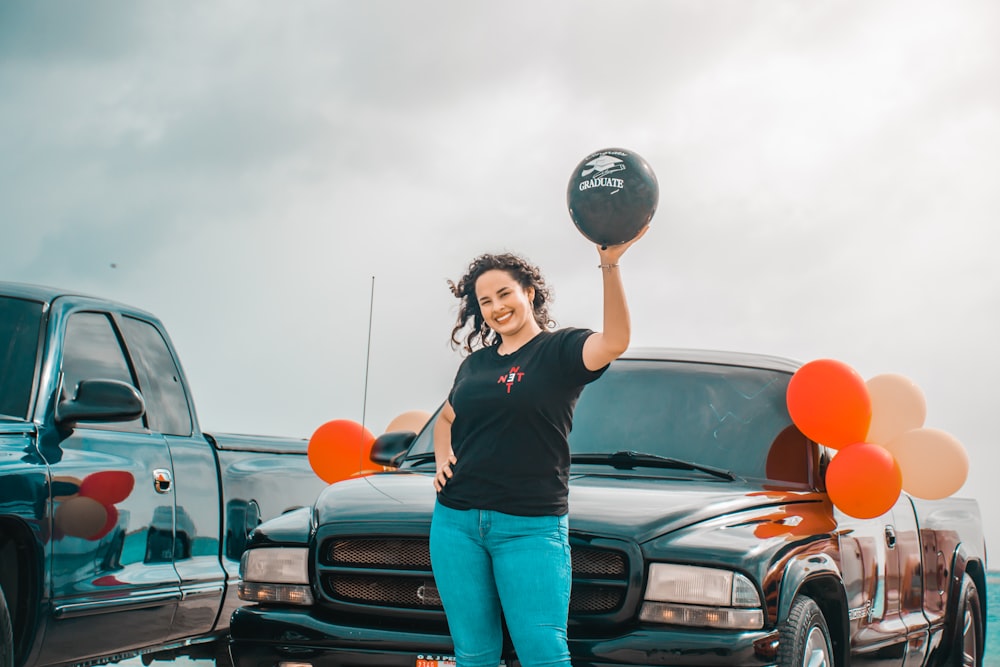 a woman holding a basketball in front of a truck