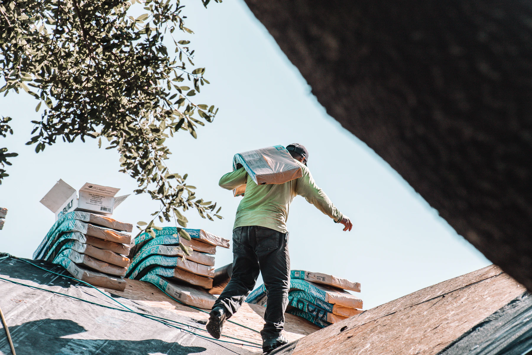 Roofing professional carrying shingles for a roof replacement