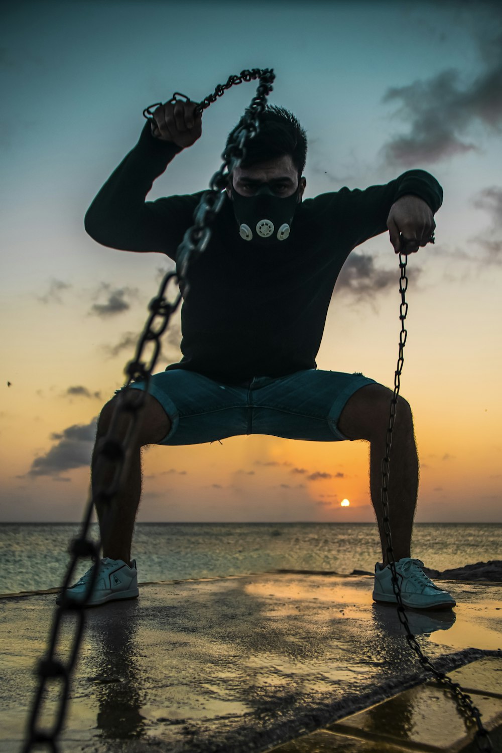a man hanging from a chain on the beach