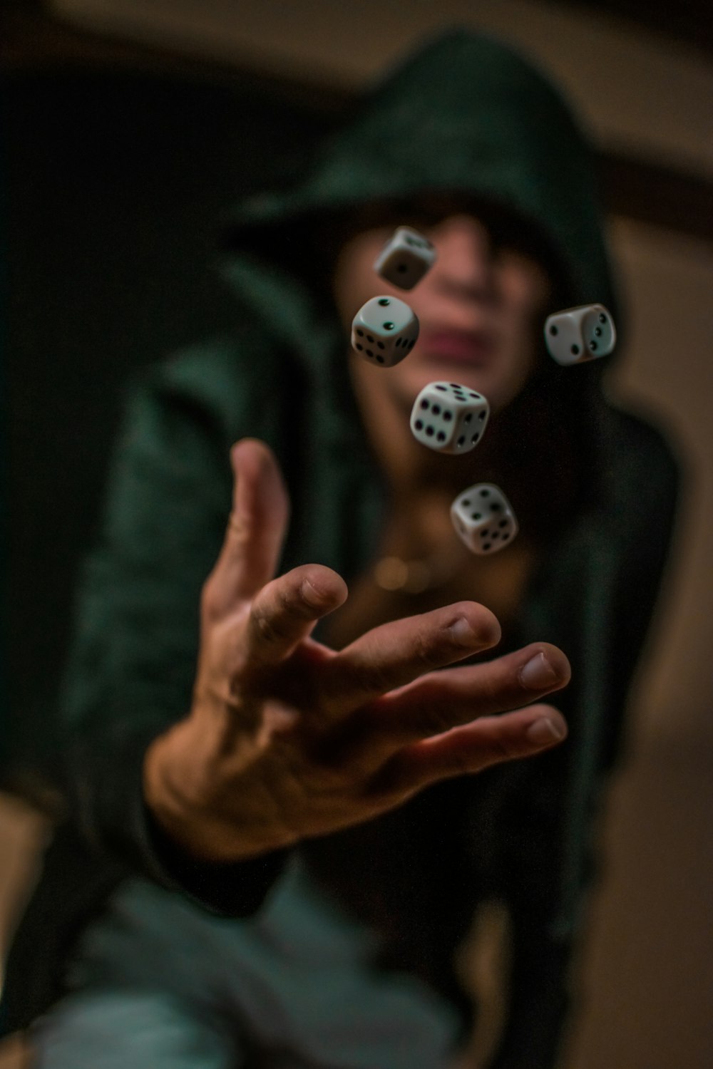 a person in a hoodie throwing dices into the air