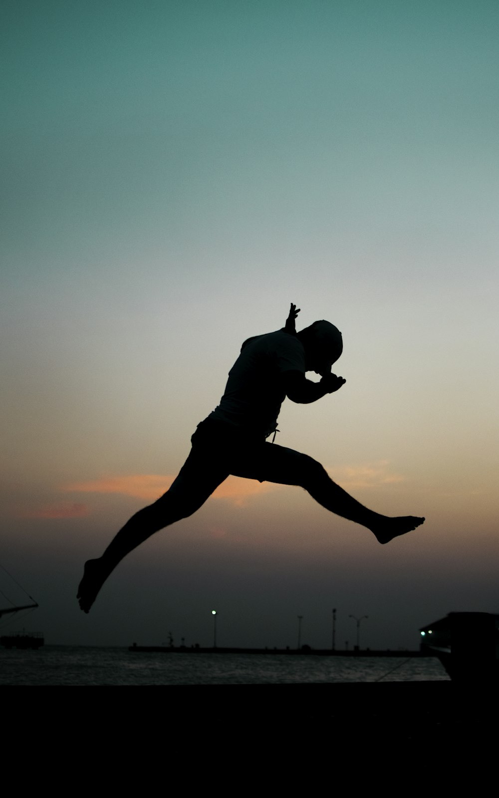 a silhouette of a man jumping into the air