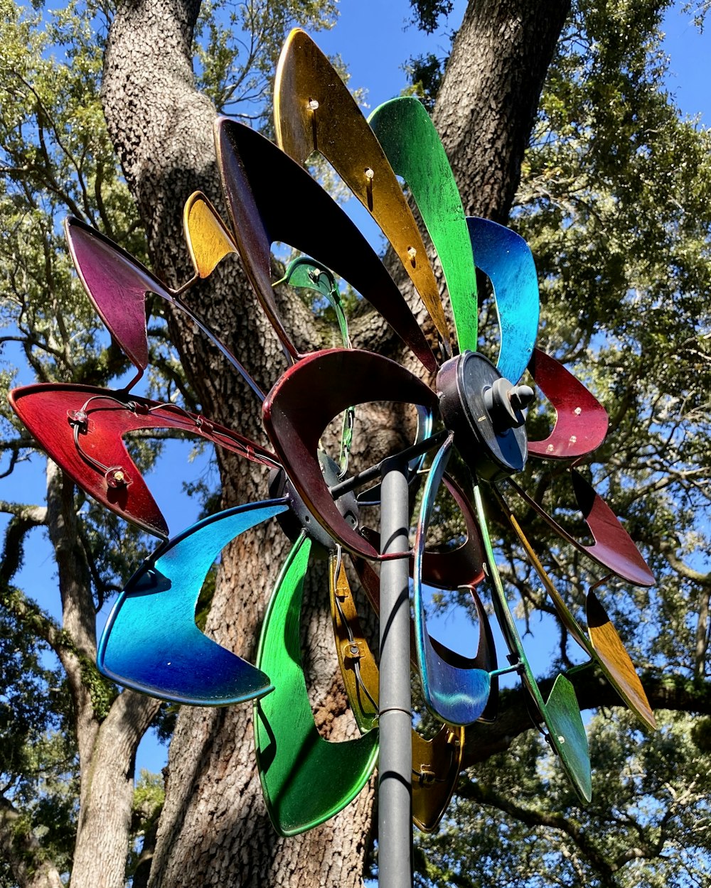a wind spinner hanging from the side of a tree