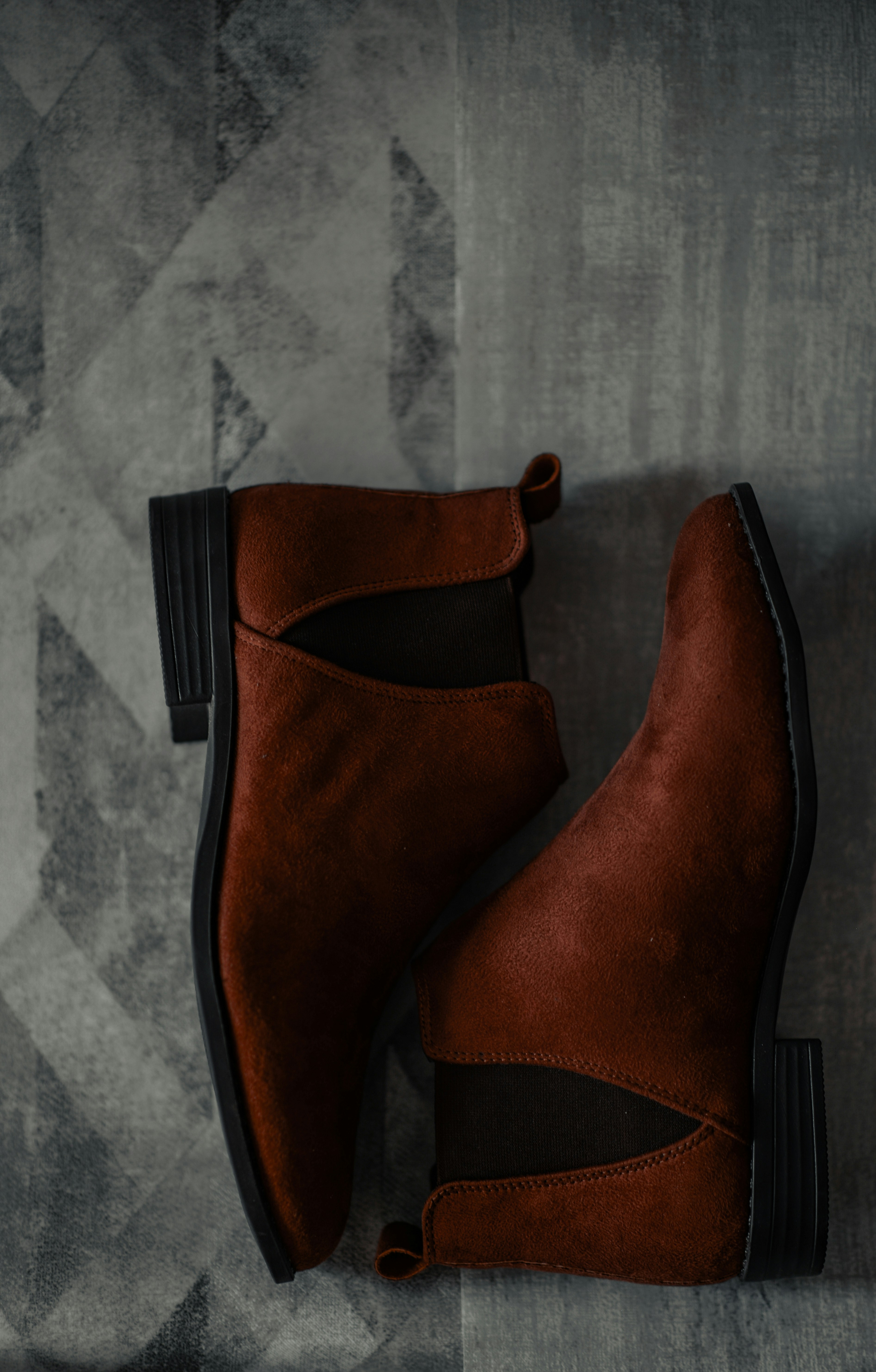 a pair of brown boots sitting on top of a floor