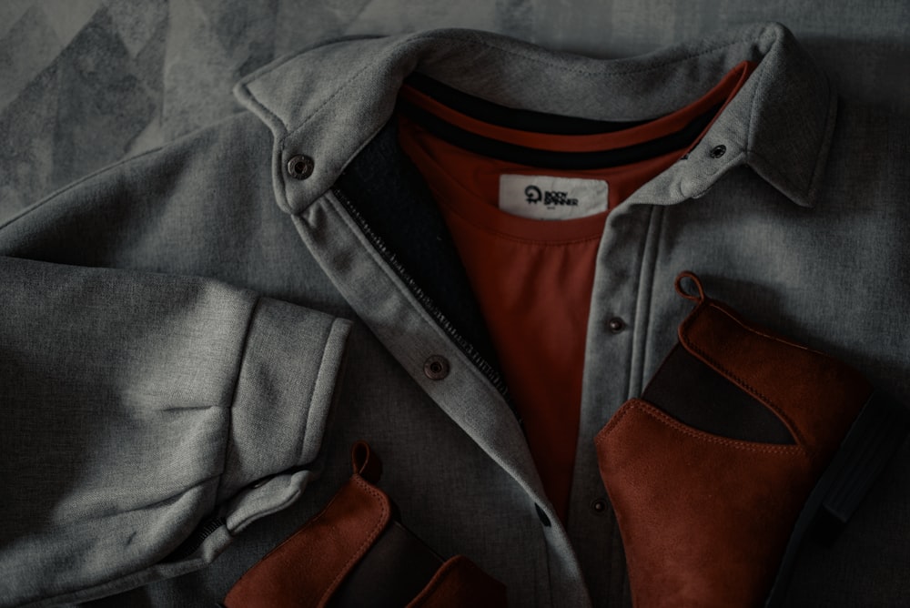 a grey jacket with a red shirt underneath it