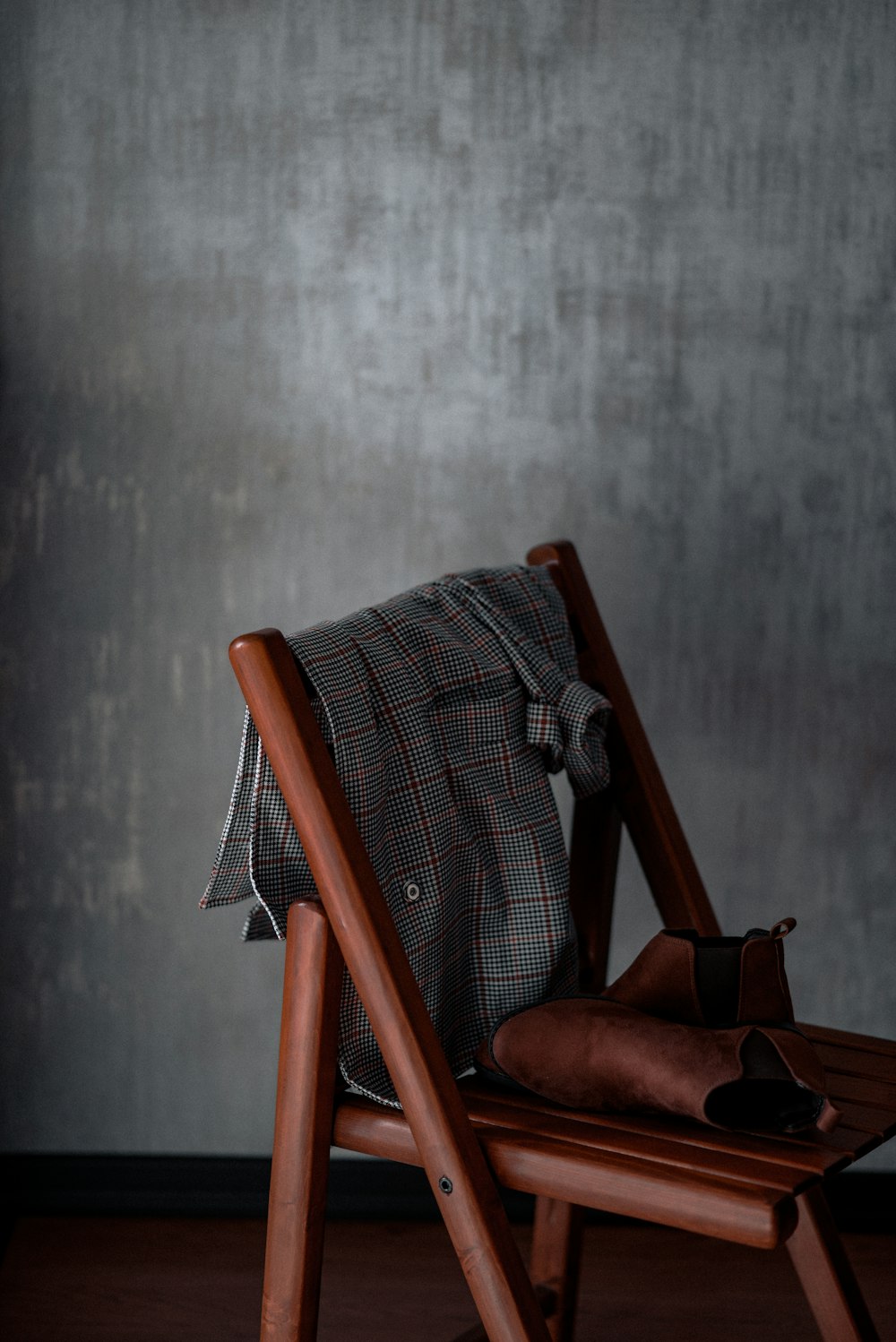 a wooden chair with a plaid pillow on top of it