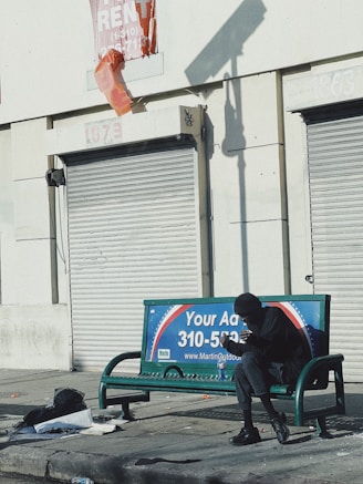 a man sitting on a bench in front of a building