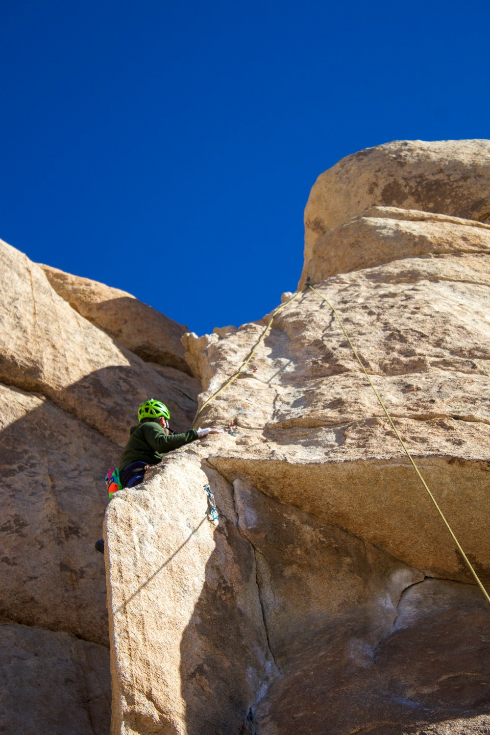 a man climbing up the side of a large rock