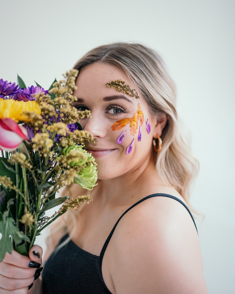 a woman holding a bouquet of flowers in front of her face