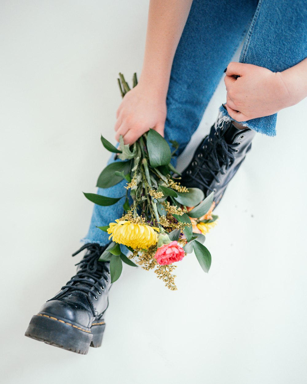 a woman is holding a bunch of flowers