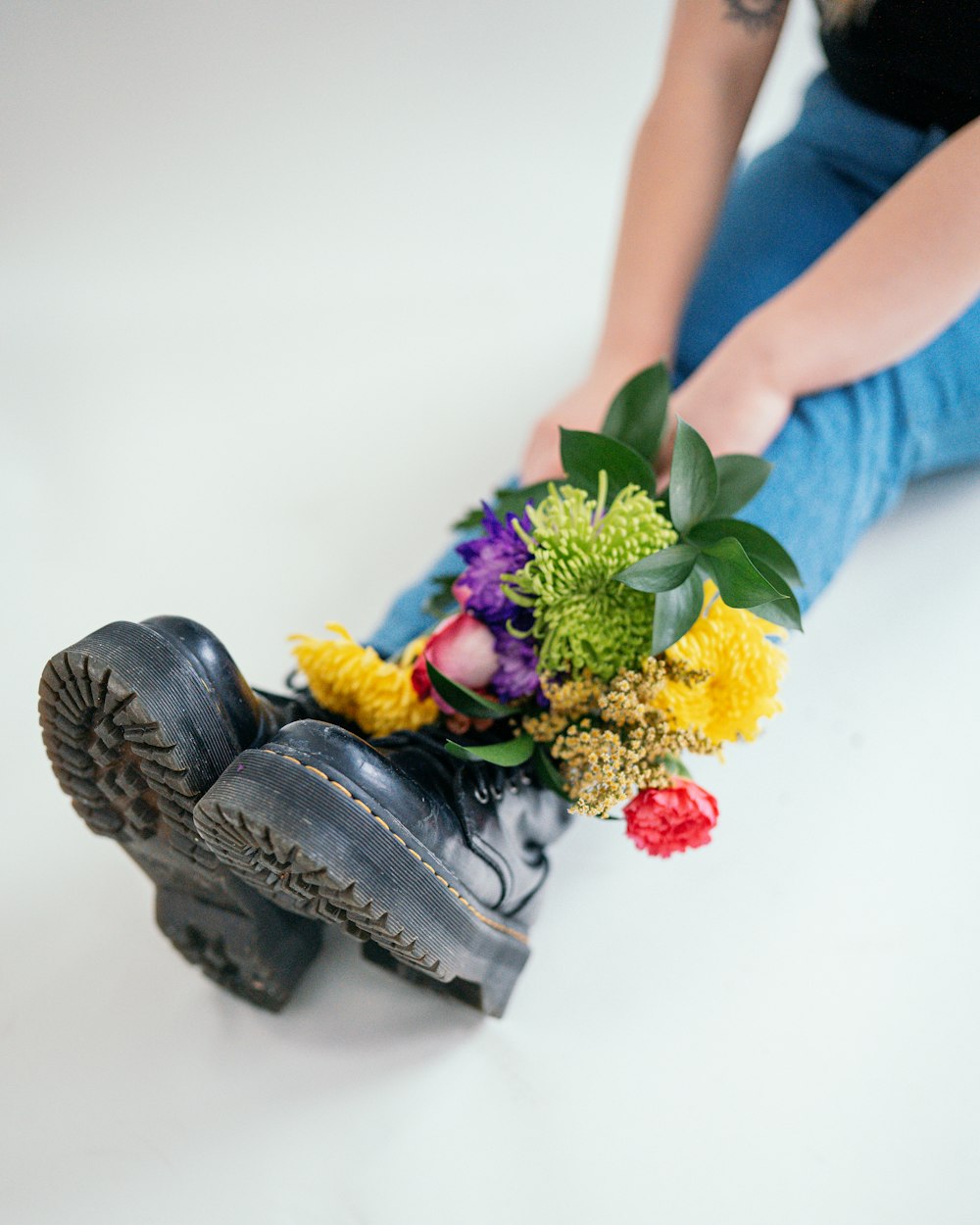 a woman sitting on the ground with a bunch of flowers