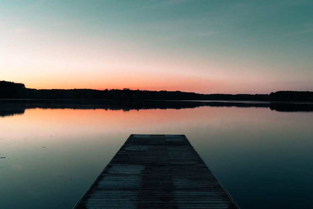 a dock sitting on top of a lake next to a forest