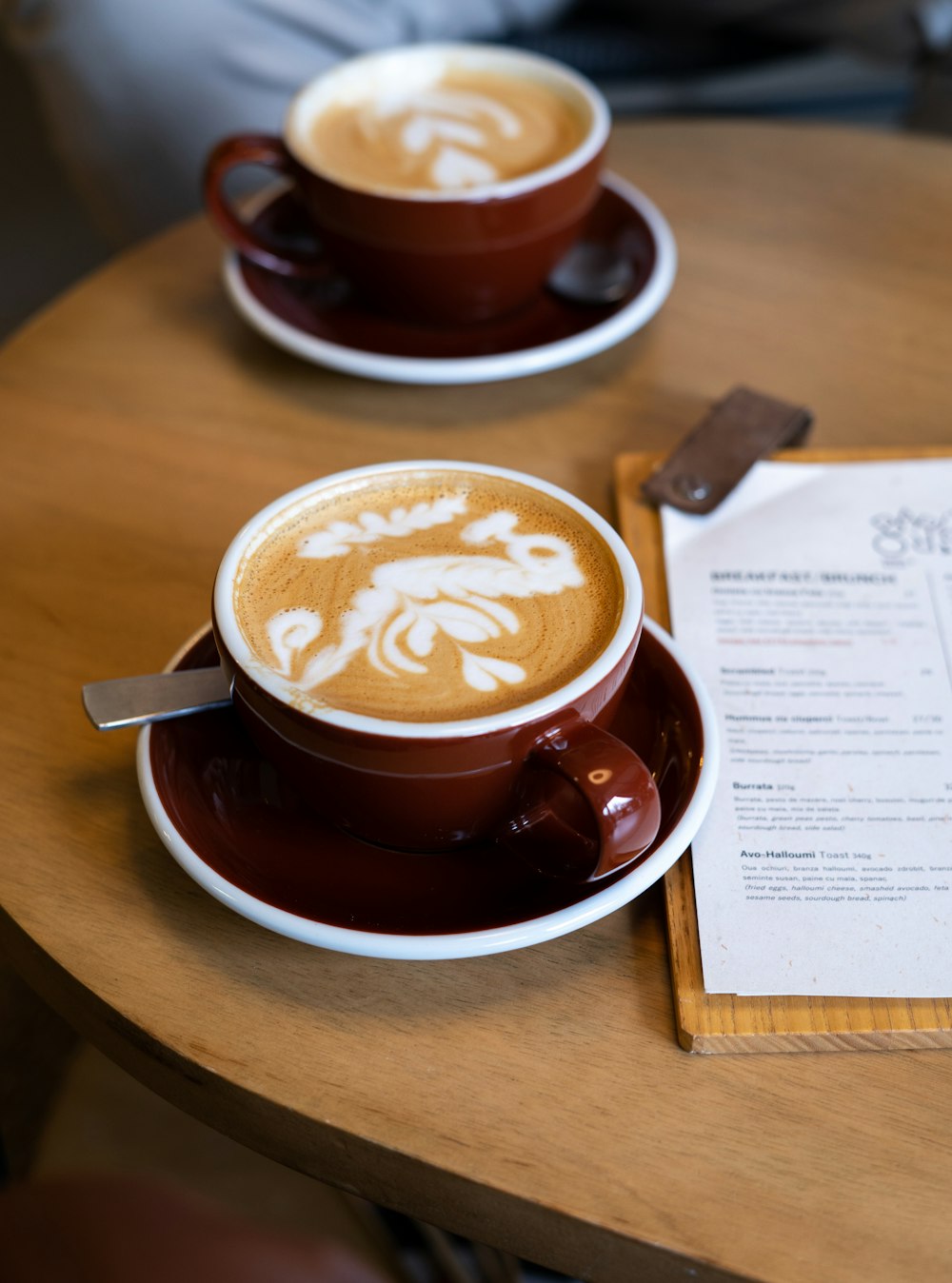 two cups of cappuccino sit on a table