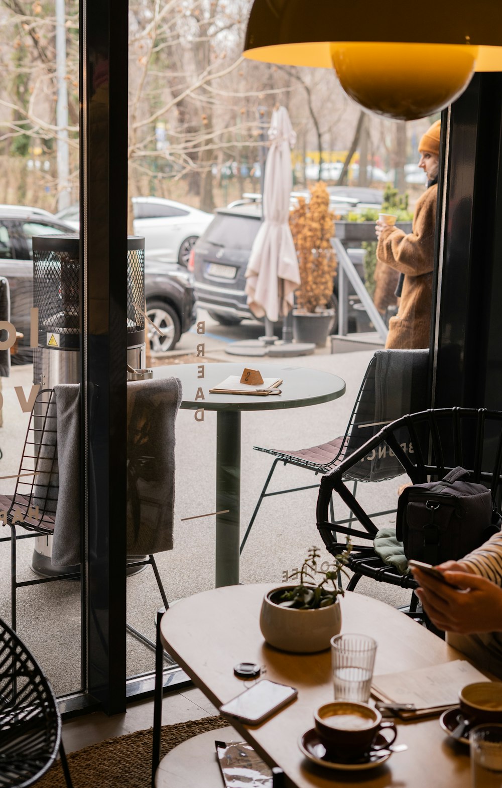 a person sitting at a table in front of a window