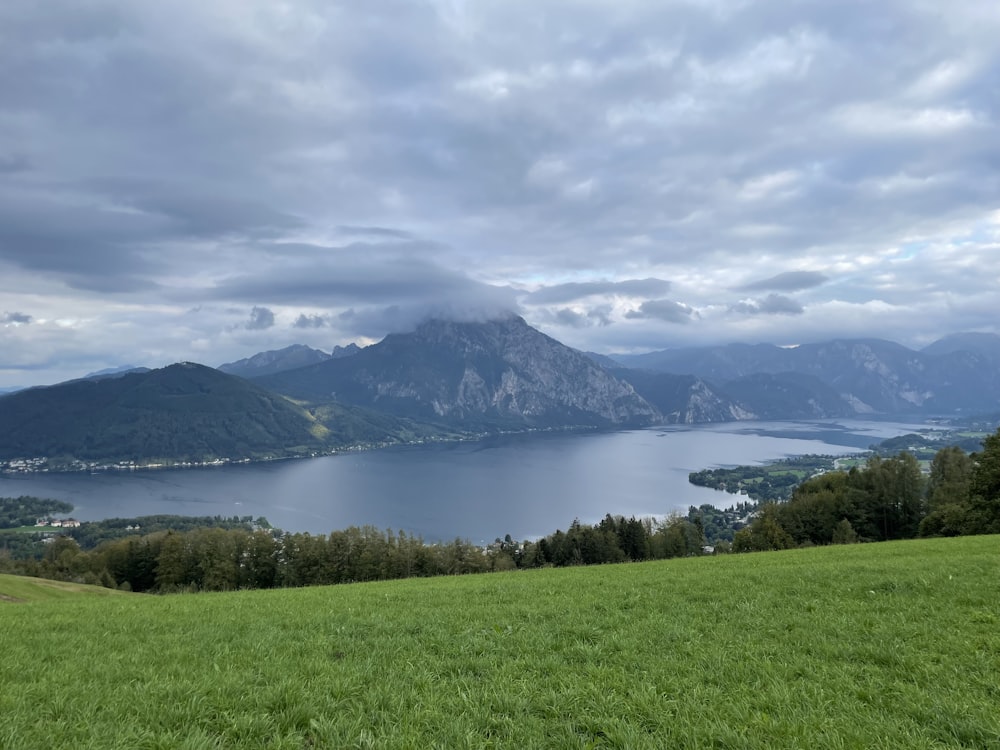 a large body of water sitting on top of a lush green hillside