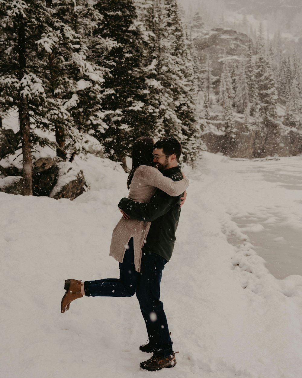 a man and woman hugging in the snow