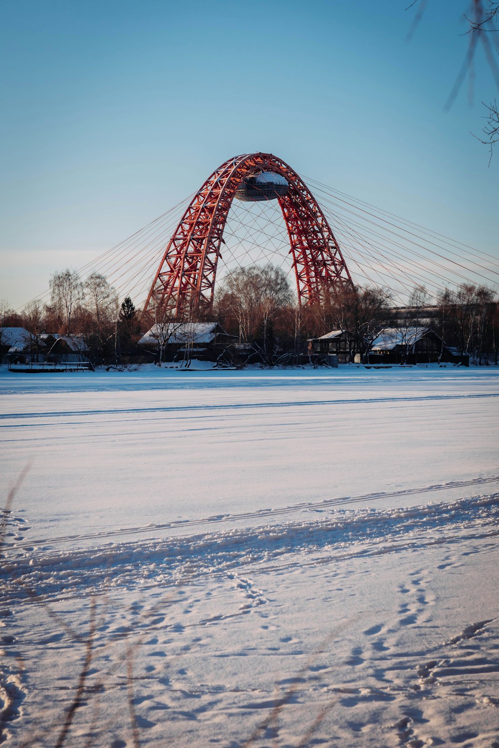 a large red bridge over a frozen lake