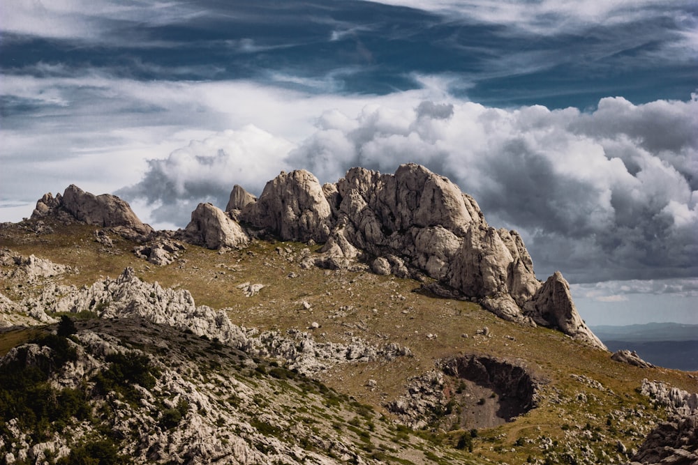 a rocky mountain with clouds in the sky