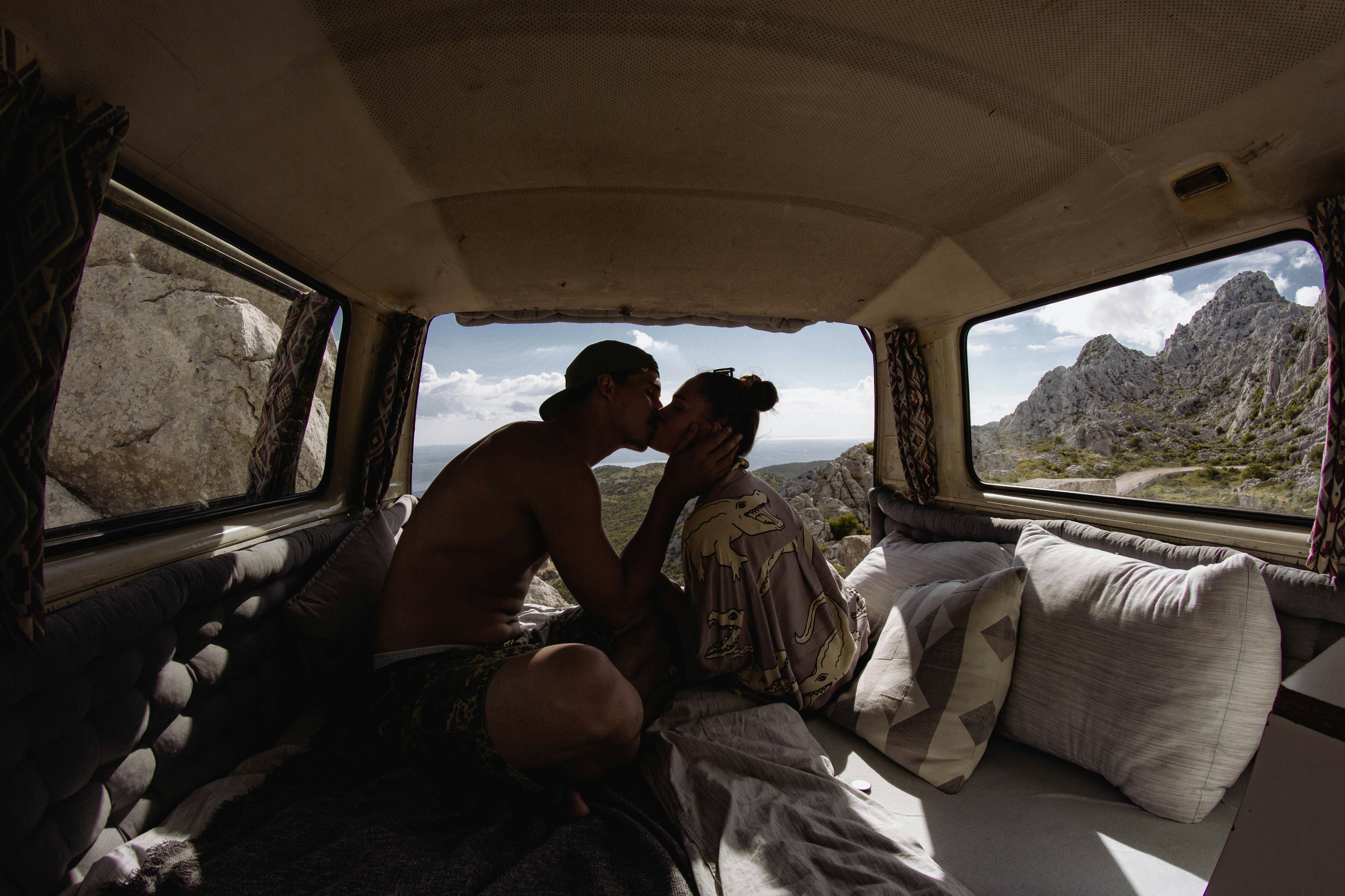 a man and woman kissing in the back of a van