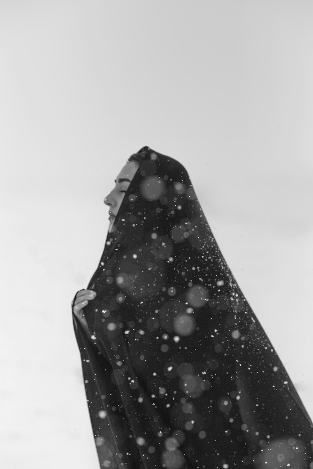 a woman in a black dress standing in the snow