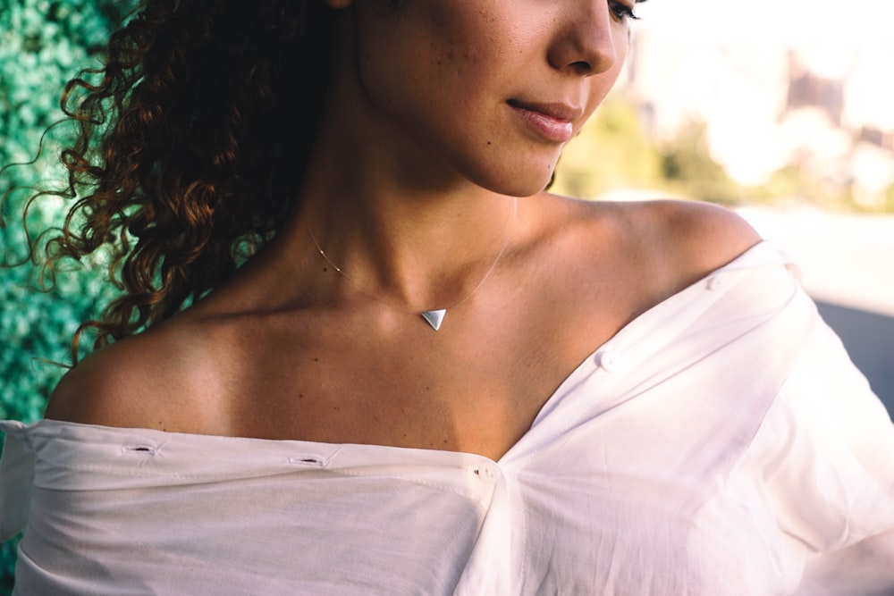 a woman in a white top is posing for a picture