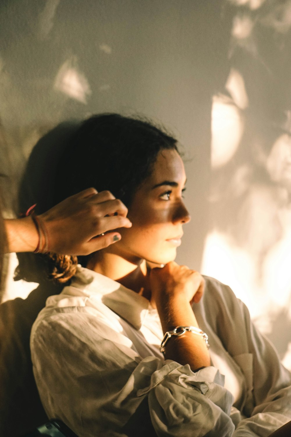 a woman sitting down with her hands on her chin