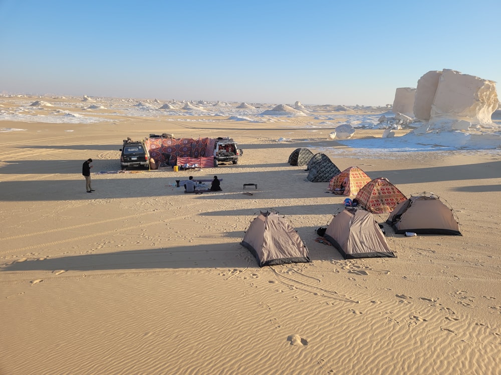 a group of tents sitting on top of a sandy beach