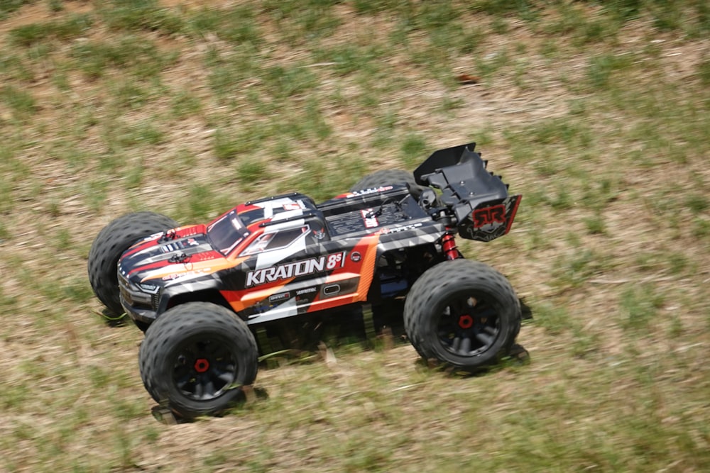 a remote controlled monster truck driving through a field