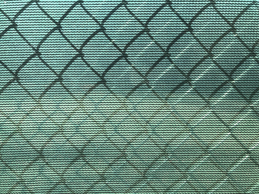 a close up of a window with a fence in the background