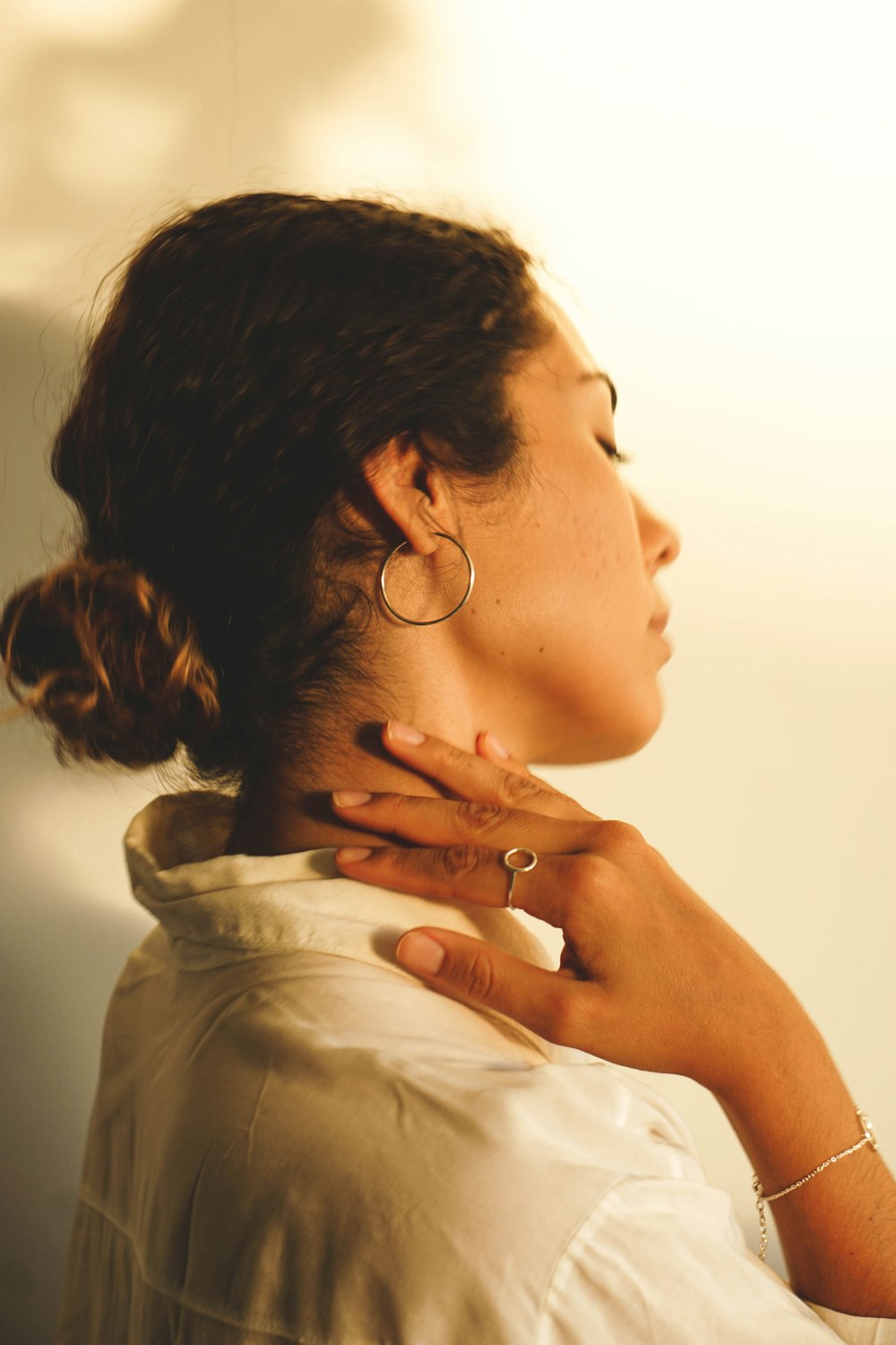 a woman wearing a white shirt and gold hoop earrings