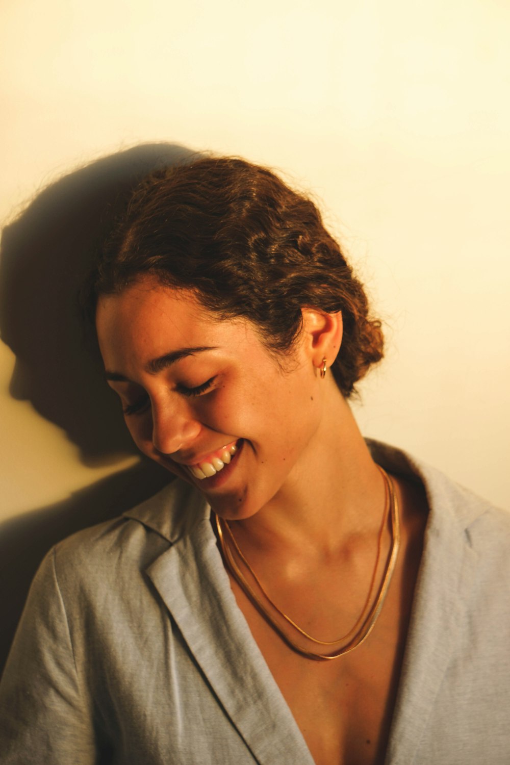 a woman smiling while wearing a necklace