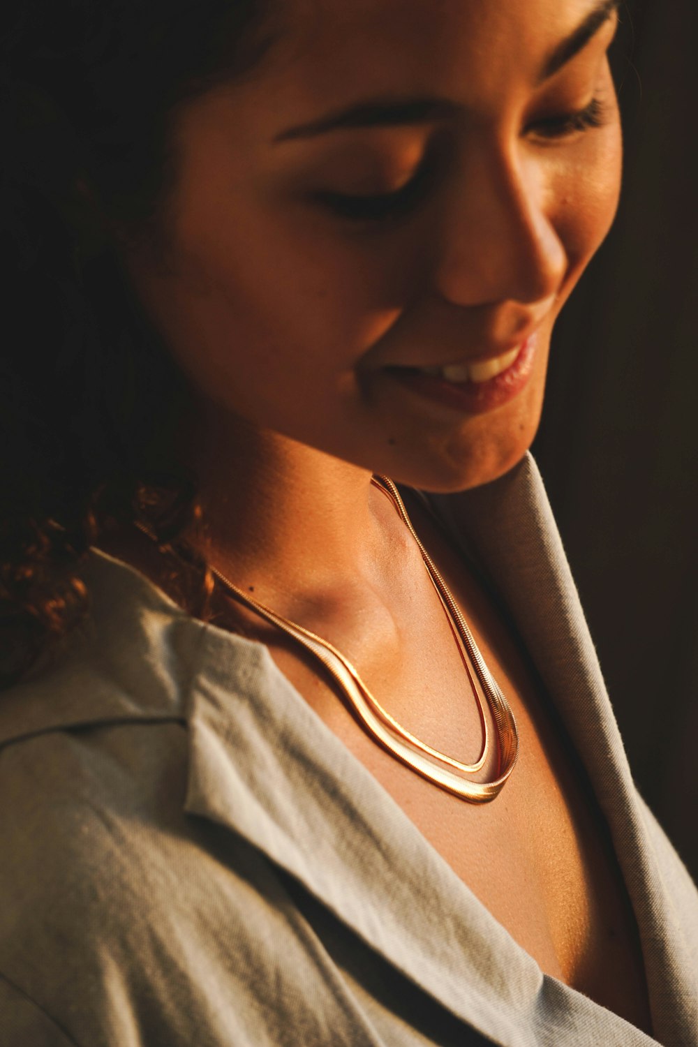 a woman is smiling and wearing a necklace
