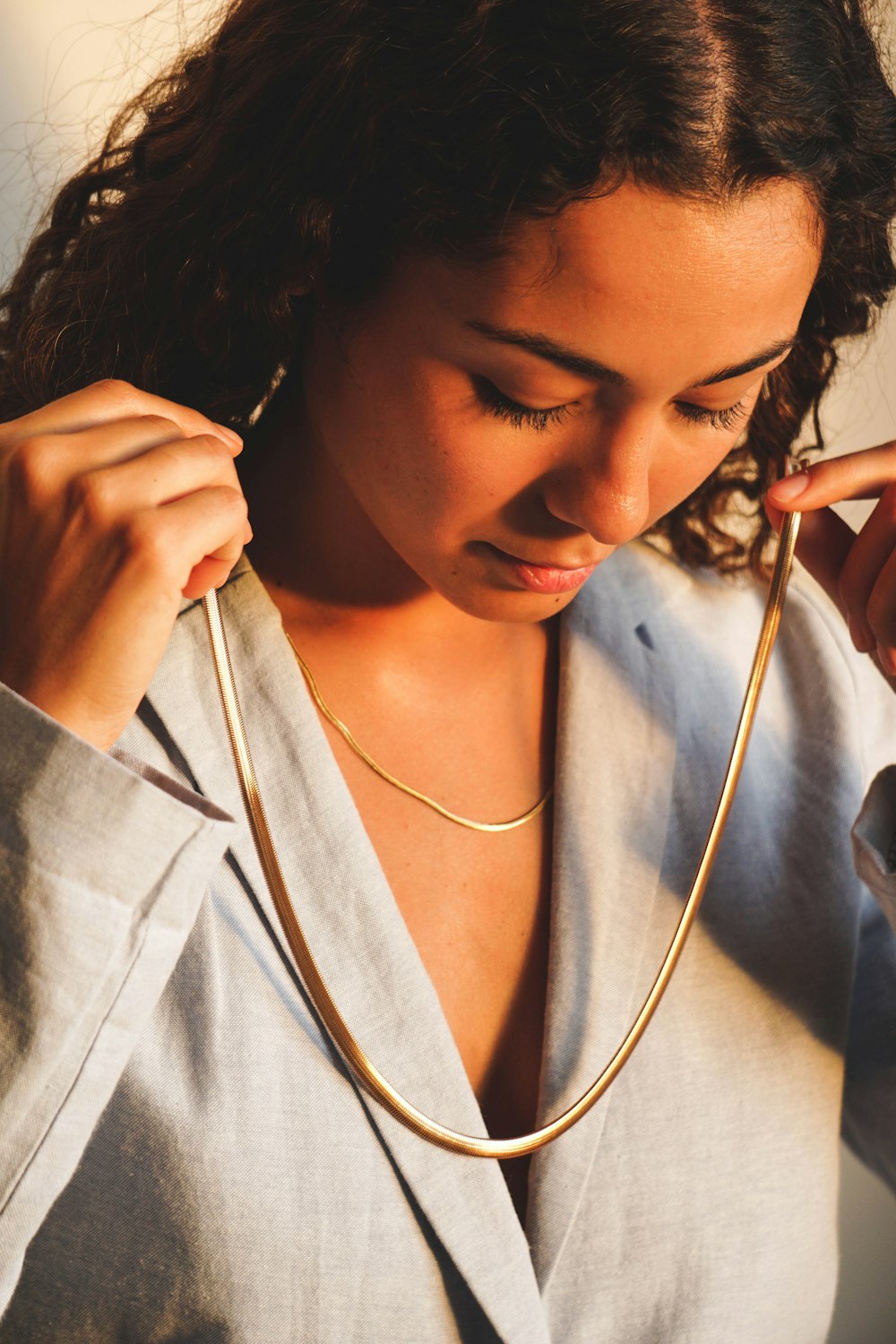 a woman wearing a necklace and a shirt