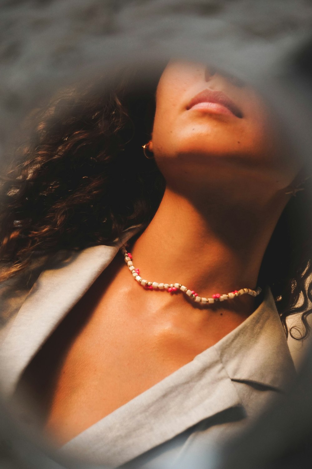 a woman with her eyes closed wearing a necklace