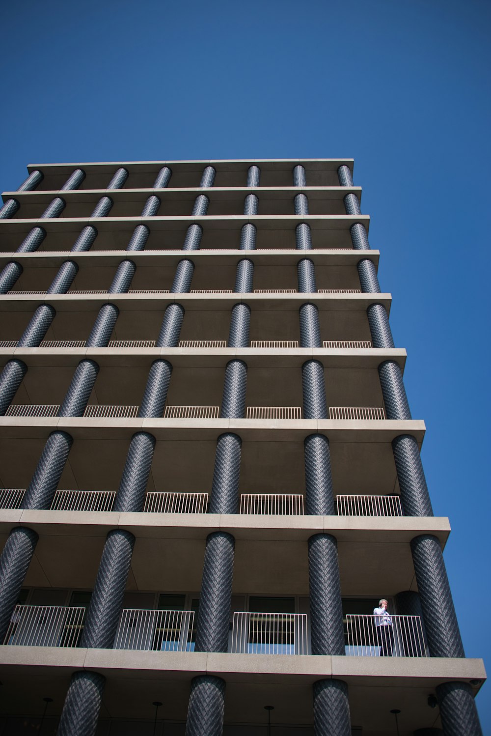 a tall building with a man standing on the balcony