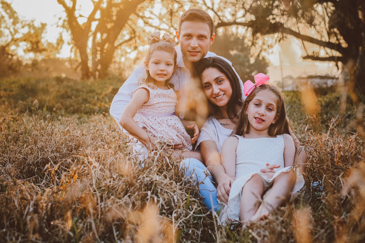 A father and his two daughters in a field