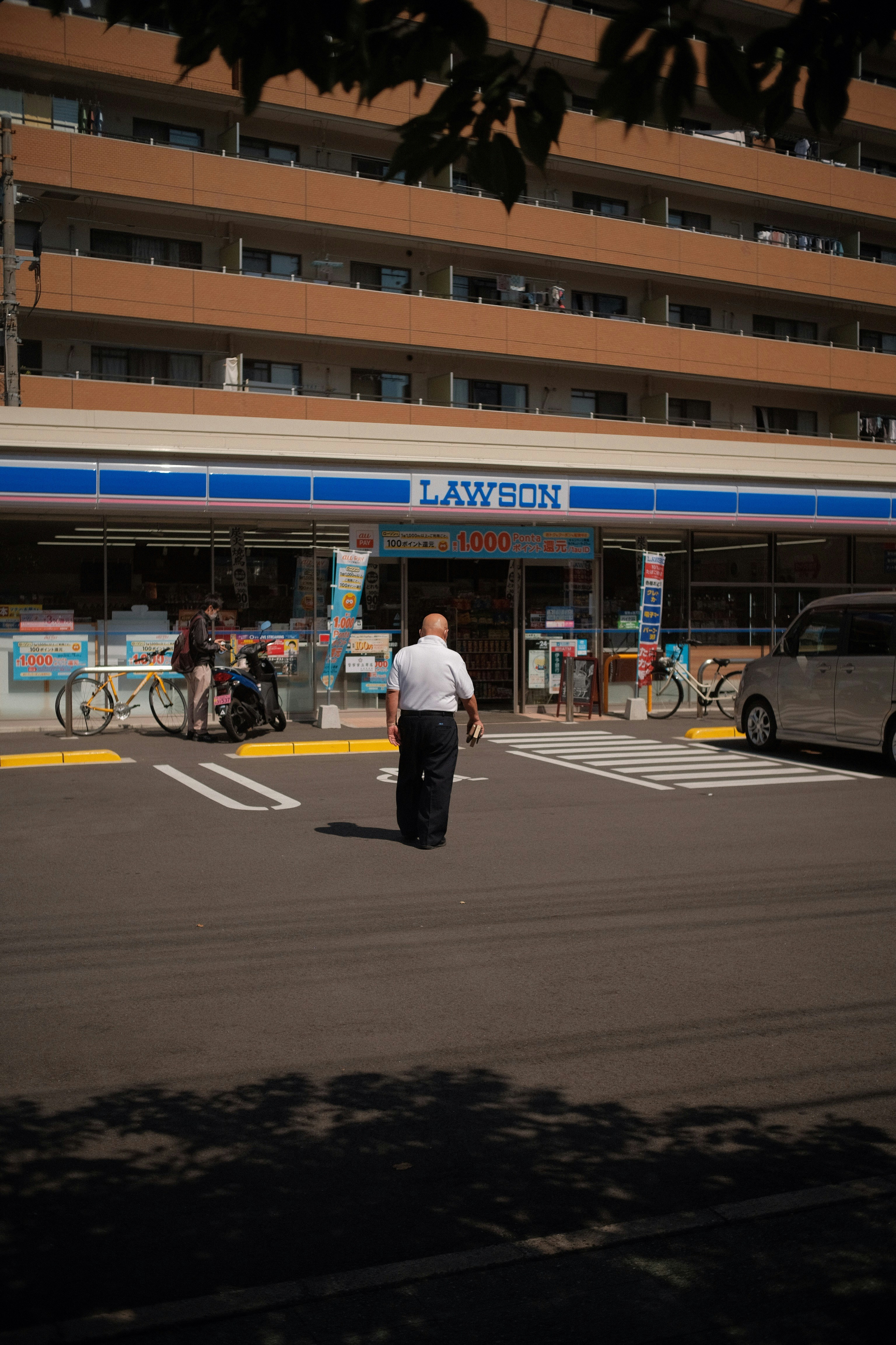 a man walking across a street in front of a building