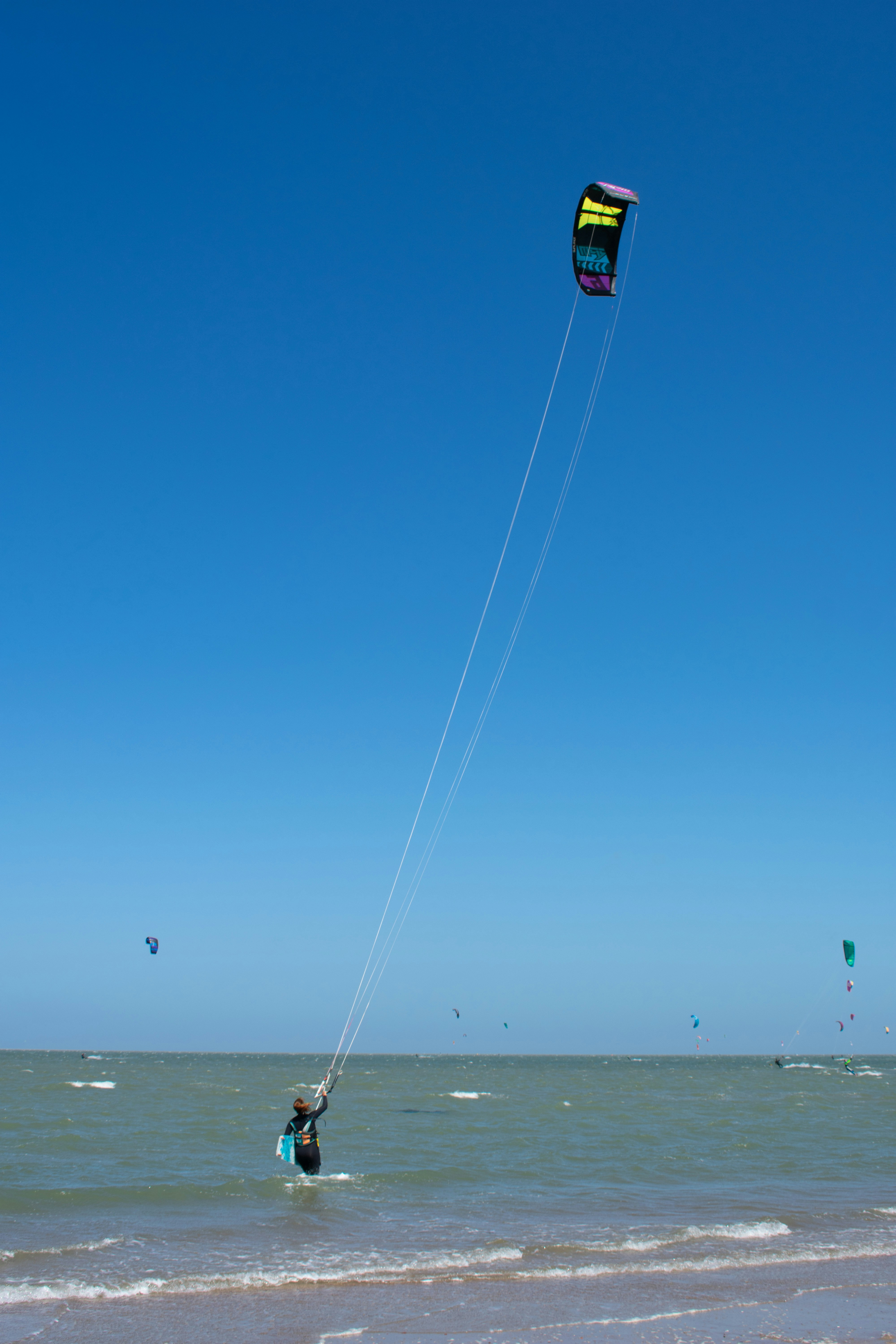 a person on a beach flying a kite