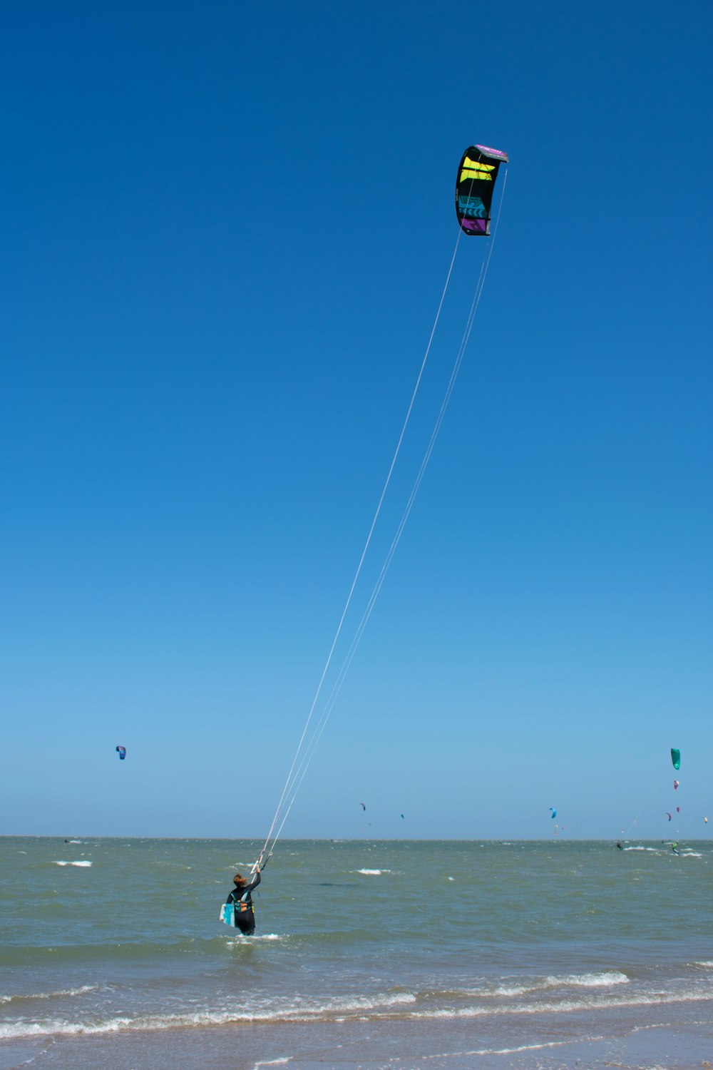 a person on a beach flying a kite