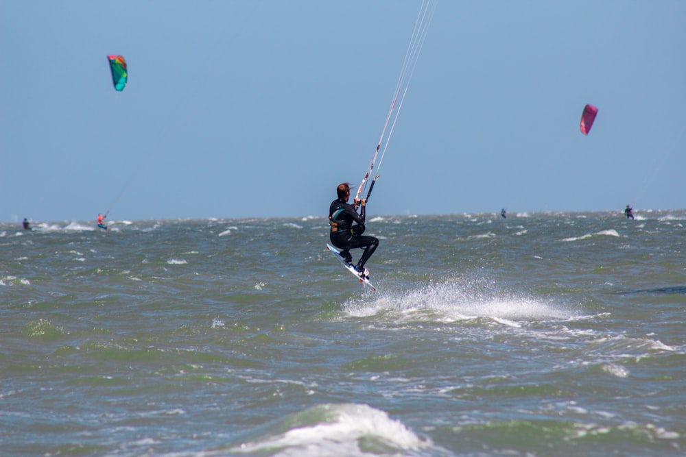 a man riding a kiteboard on top of a wave in the ocean