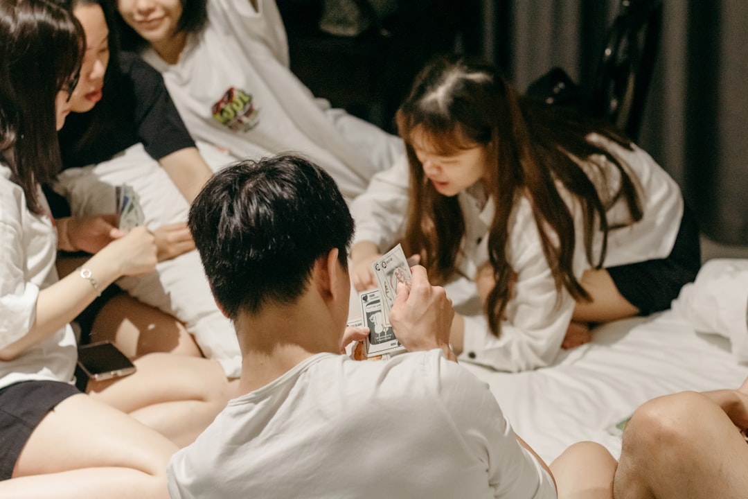 a group of people sitting around each other on a bed,
