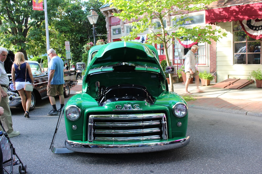 a green truck parked on the side of a road