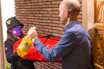 A customer happily receiving a package at home with 'paga contra entrega' service