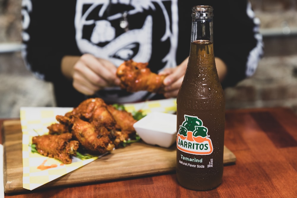 a person sitting at a table with a bottle of beer