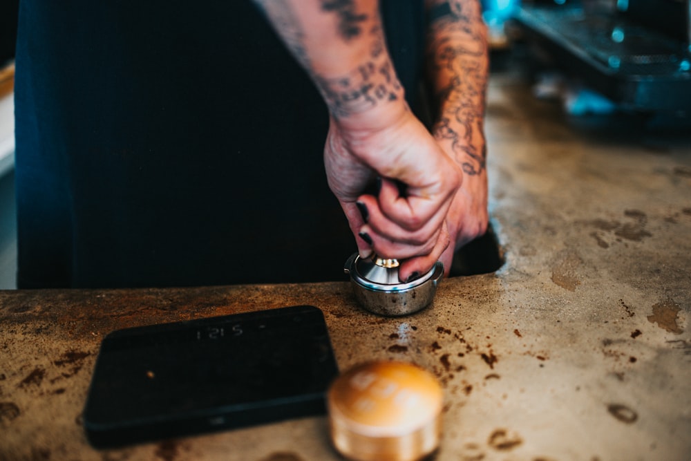 uma pessoa com tatuagens está preparando comida em um balcão