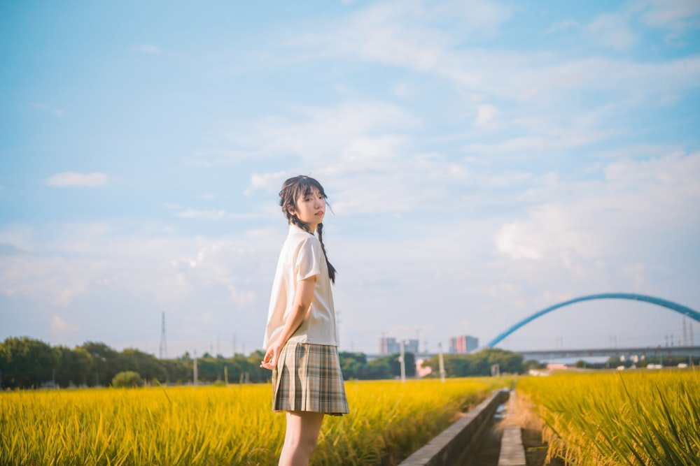 a woman standing in a field of tall grass