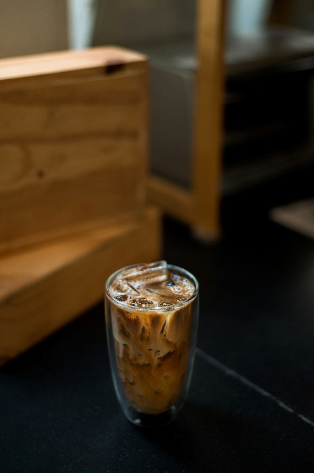 a glass of iced coffee sitting on a table